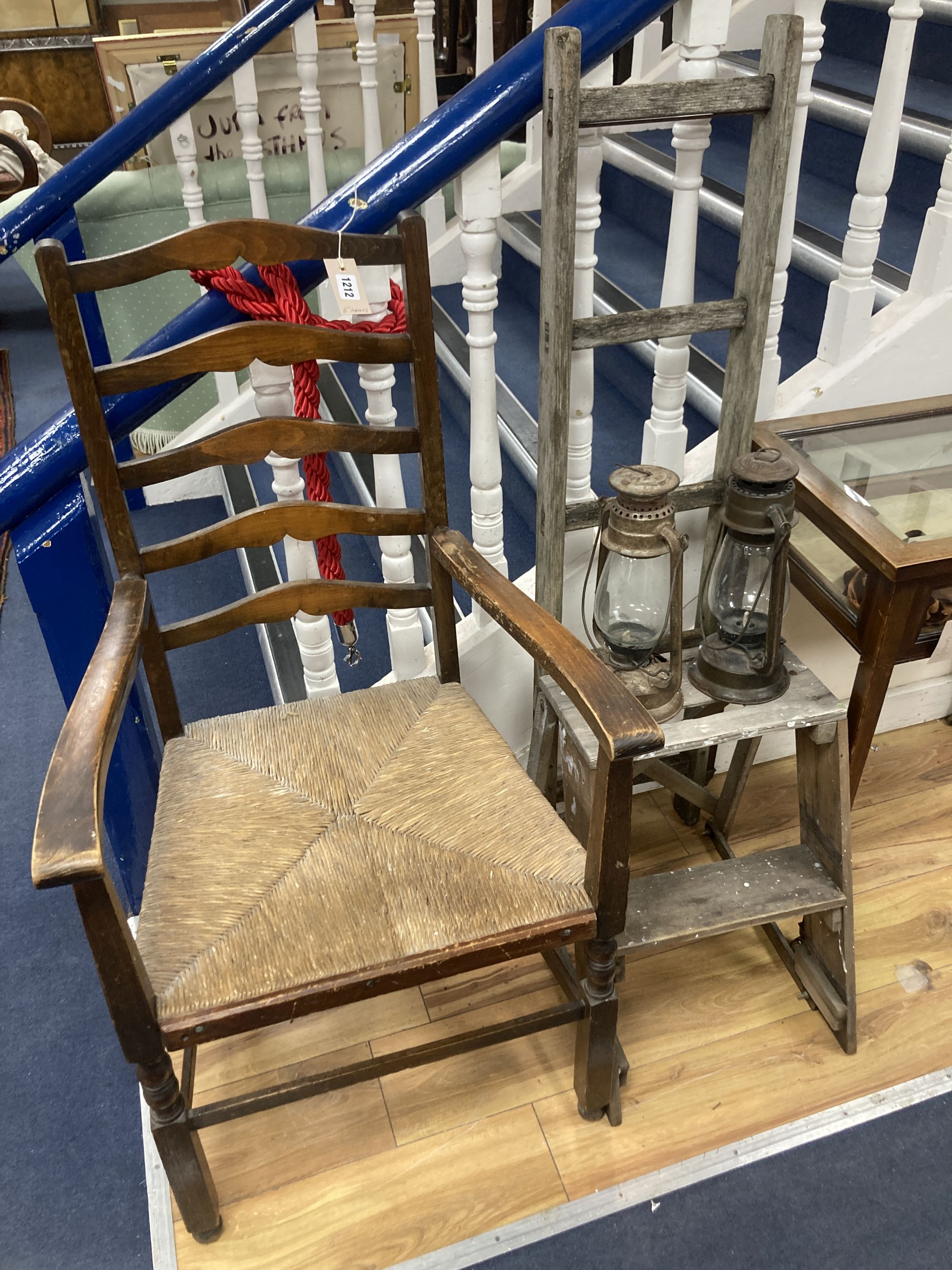 A rush seated beech elbow chair, a vintage five tread step ladder, a similar pine step stool and two oil lamps